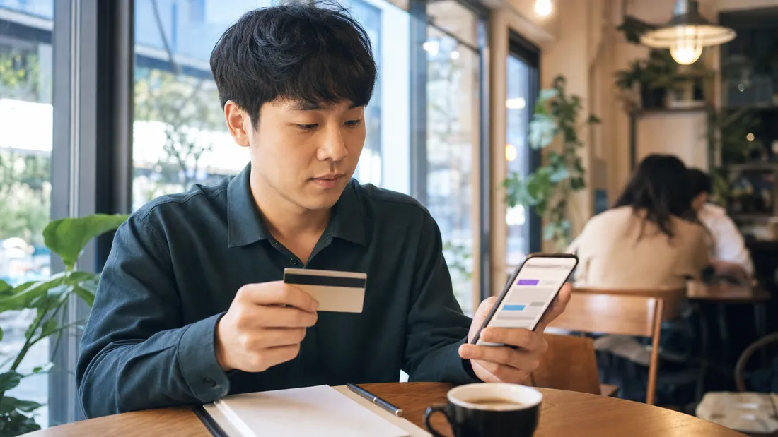 카페에서 카드 혜택을 폰으로 비교하는 모습